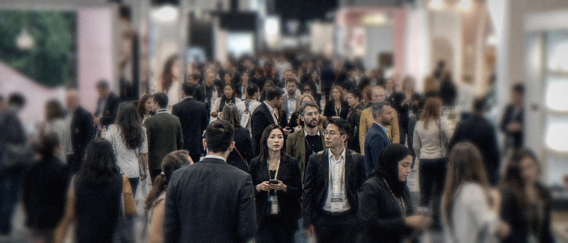 A crowded trade show hall at Cosmoprof Worldwide Bologna, buyers and exhibitors from around the world circulating between beauty brand booths